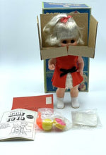 Load image into Gallery viewer, Lifestyle shot of the 1967 Mattel Walk n Play doll with accessories in a box.
