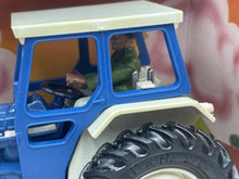 Load image into Gallery viewer, Britains Ford 6600 tractor cabin detail showing interior and driver figure in blue and green.
