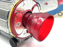 Load image into Gallery viewer, Detail view of the red metallic lens on the vintage battery-operated space capsule toy.
