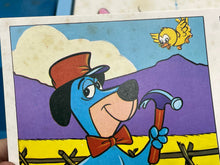 Load image into Gallery viewer, Detail of a cartoon character against a mountain background in the bingo game.
