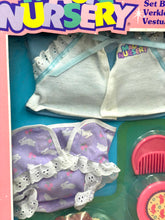 Load image into Gallery viewer, Detail close-up of toy nursery accessories featuring baby clothes in white and purple.
