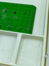 Load image into Gallery viewer, Close-up of the green game board from GRAND PRIX featuring a grid pattern and small icons.
