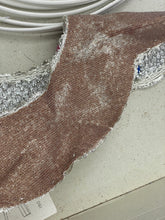 Carica l'immagine nel visualizzatore di Gallery, Detail shot of brown fabric with textured surface and curved edge
