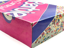 Carica l'immagine nel visualizzatore di Gallery, Close-up of Barbie packaging corner with colorful sprinkles and graphic design.
