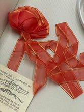 Carica l'immagine nel visualizzatore di Gallery, Ferrari Mazzini close-up of a red ribbon featuring sheer fabric and gold accents.
