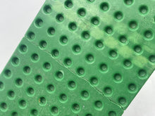Carica l'immagine nel visualizzatore di Gallery, Close-up of green building plate showing studs and textured surface.

