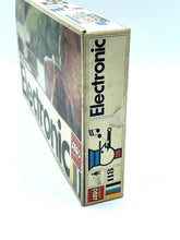 Load image into Gallery viewer, Side view of the vintage LEGO 118 4.5V electronic train in its box.
