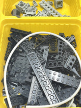 Carica l'immagine nel visualizzatore di Gallery, Various gray LEGO parts stored in bins, showcasing plastic components.
