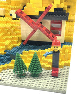Carica l'immagine nel visualizzatore di Gallery, LEGO figure close-up standing on yellow bricks while holding a black object.
