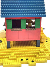 Carica l'immagine nel visualizzatore di Gallery, Front view of the colorful toy house with two windows and a sloped roof.
