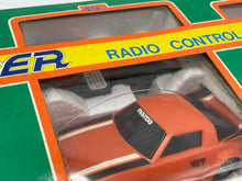 Load image into Gallery viewer, Detail view of an orange toy truck with a detailed design and brand name.

