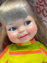 Load image into Gallery viewer, Close-up detail of Ideal Toy Giggles doll's smiling face and colorful outfit.
