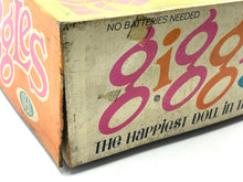 Load image into Gallery viewer, Detail close-up of the text logo on the Ideal Toy Giggles doll packaging.
