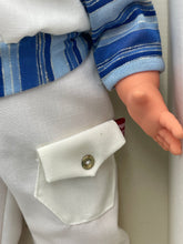 Load image into Gallery viewer, Close-up of Sebino Doll's hand featuring a button pocket and striped shirt.
