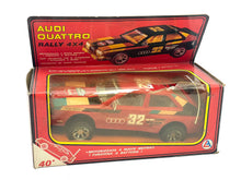 Load image into Gallery viewer, Packaging view of the Audi Quattro Rallye toy car featuring red, black, and yellow colors.
