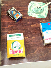 Load image into Gallery viewer, Lifestyle shot of various items including a cigarette pack and green dish on a table.
