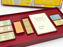 Load image into Gallery viewer, Detail shot of various game components including colorful cards and an instruction booklet.
