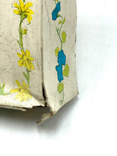 Load image into Gallery viewer, Side view of the packaging edge with decorative flowers and a damaged edge.
