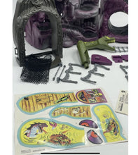 Load image into Gallery viewer, Mattel Masters of the Universe Snake Mountain colorful stickers and accessories on display.
