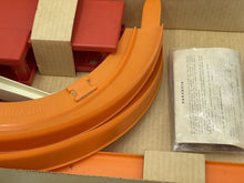 Load image into Gallery viewer, Detail close-up of orange curved track pieces and packaging materials.
