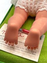 Load image into Gallery viewer, Detail shot of Sebino Nella doll's chubby pink feet on a smooth surface.
