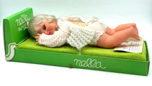 Load image into Gallery viewer, Lifestyle shot of the Sebino Nella doll posed on a bed wearing soft clothing.
