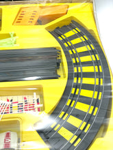 Load image into Gallery viewer, Detail view of Tyco train track layout showcasing curved track and accessory pieces.
