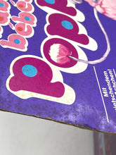 Load image into Gallery viewer, Detail of colorful packaging box with bold text and graphic design.
