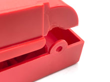 Load image into Gallery viewer, Detail view of a red stapler with a curved design and open compartment.

