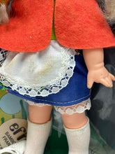Carica l'immagine nel visualizzatore di Gallery, Effe Bambole Franca close-up of the doll clothing featuring a white apron, blue skirt, and red cape.
